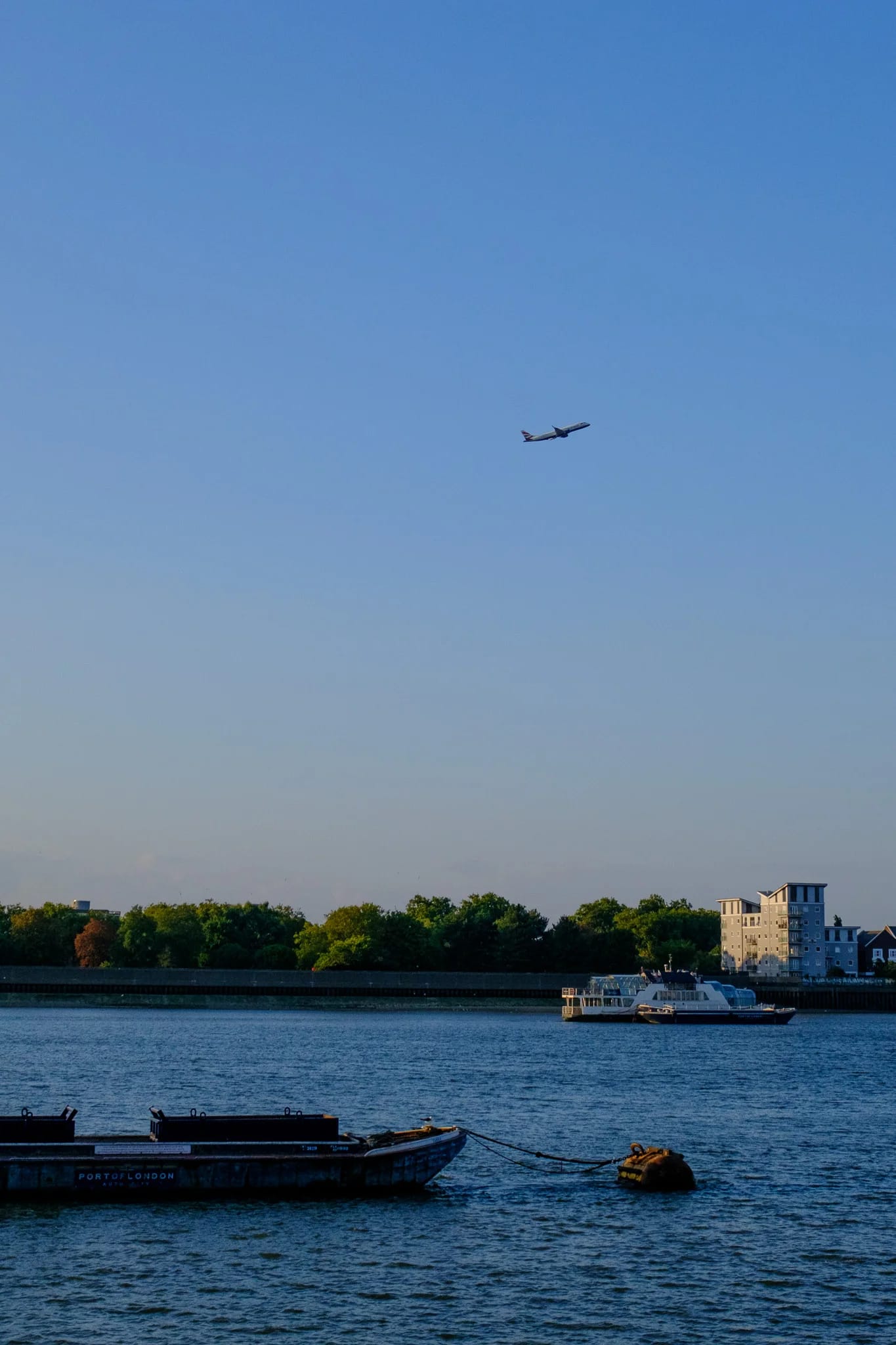 Airplane flies over London river