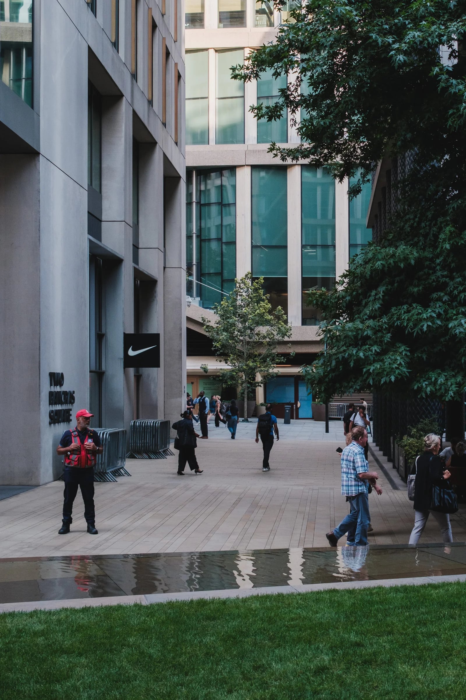 People Walking Past Modern City Buildings
