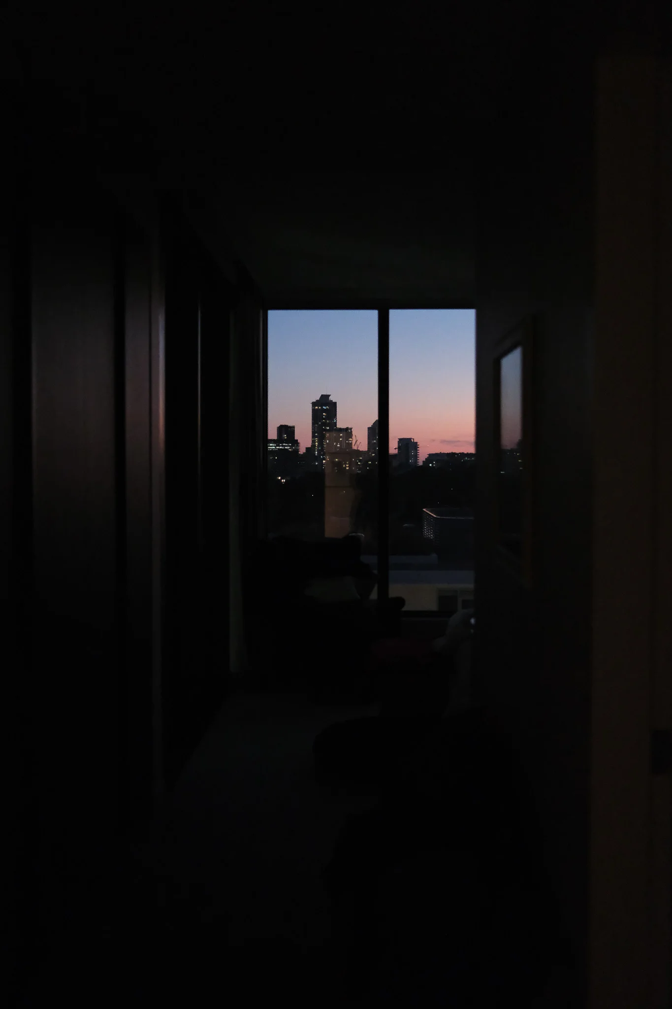 Urban skyline through a dark window