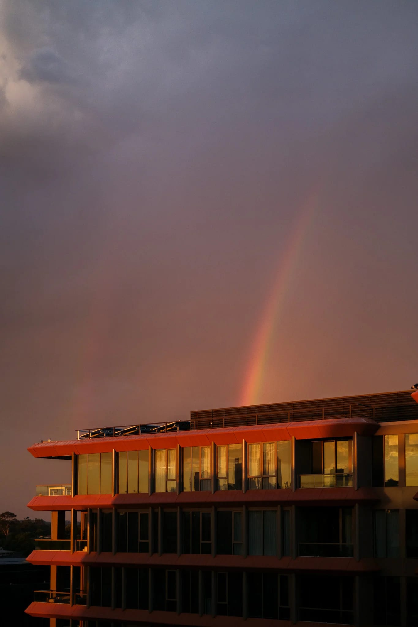 Rainbow Over Modern Architecture at Sunset