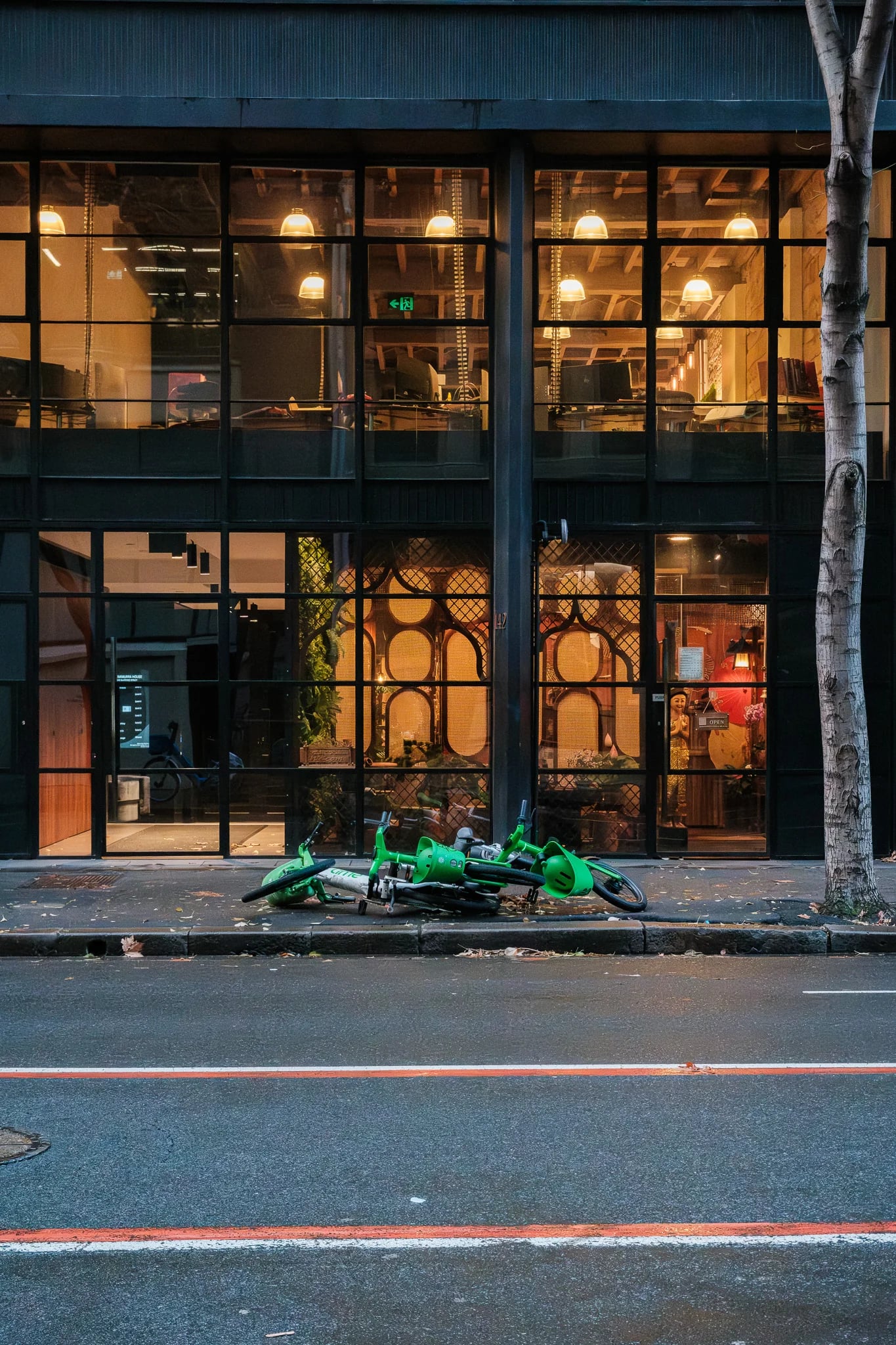 Green Scooter Lying on City Sidewalk