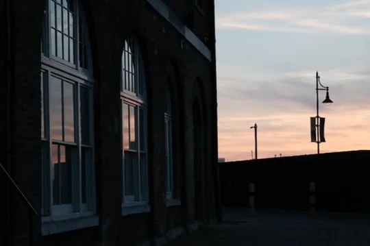 Arched windows reflect a pastel sky