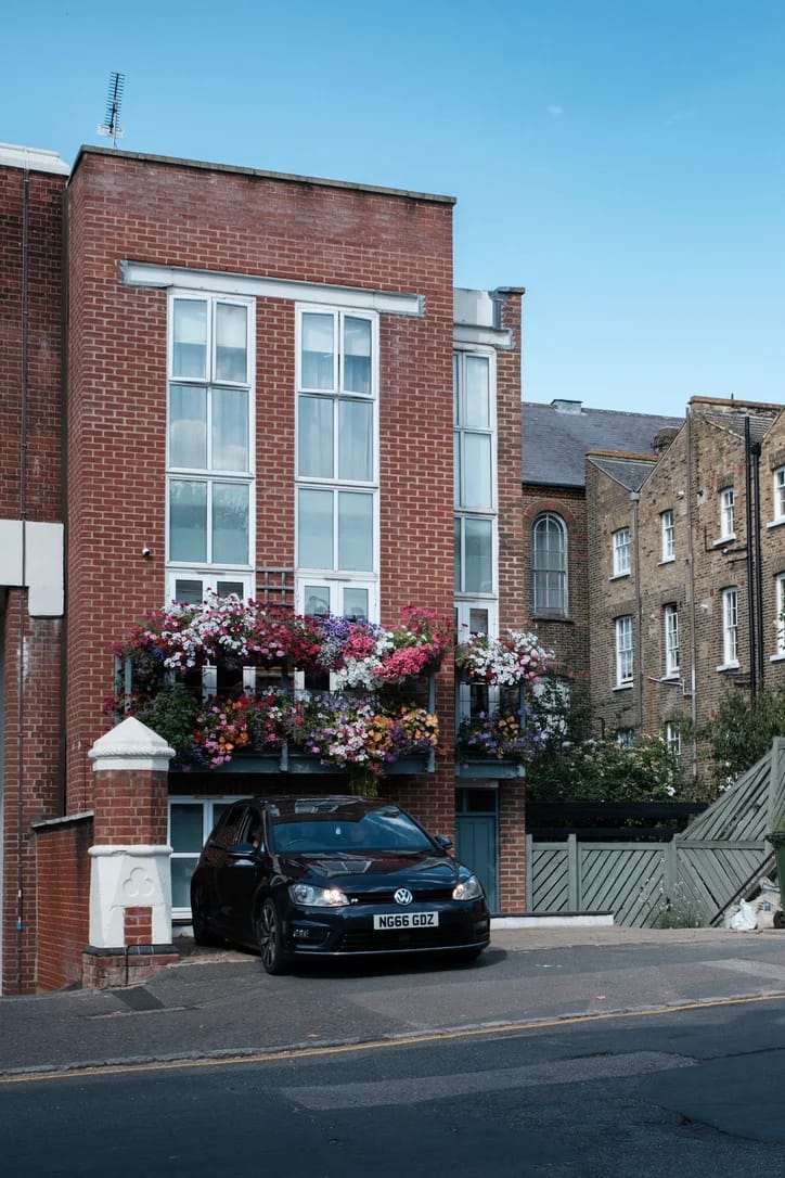 Brick building with a flower-filled balcony